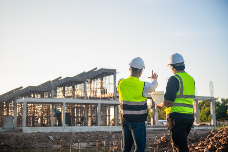 two construction workers look out over their jobsite
